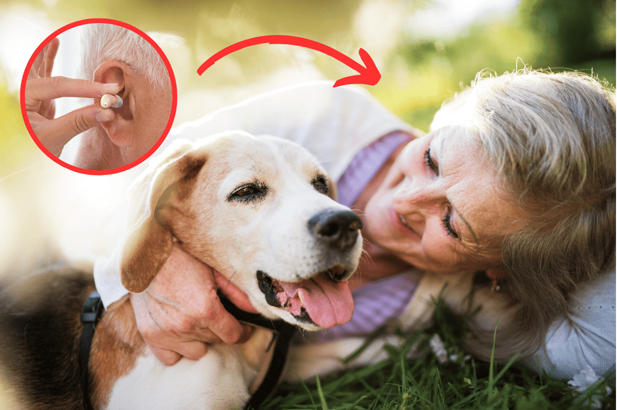 Woman and her dog having a cuddle on the grass with her Atom 2 Series hearing aids
